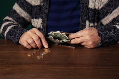 Photo of Poor senior woman with money at table, closeup
