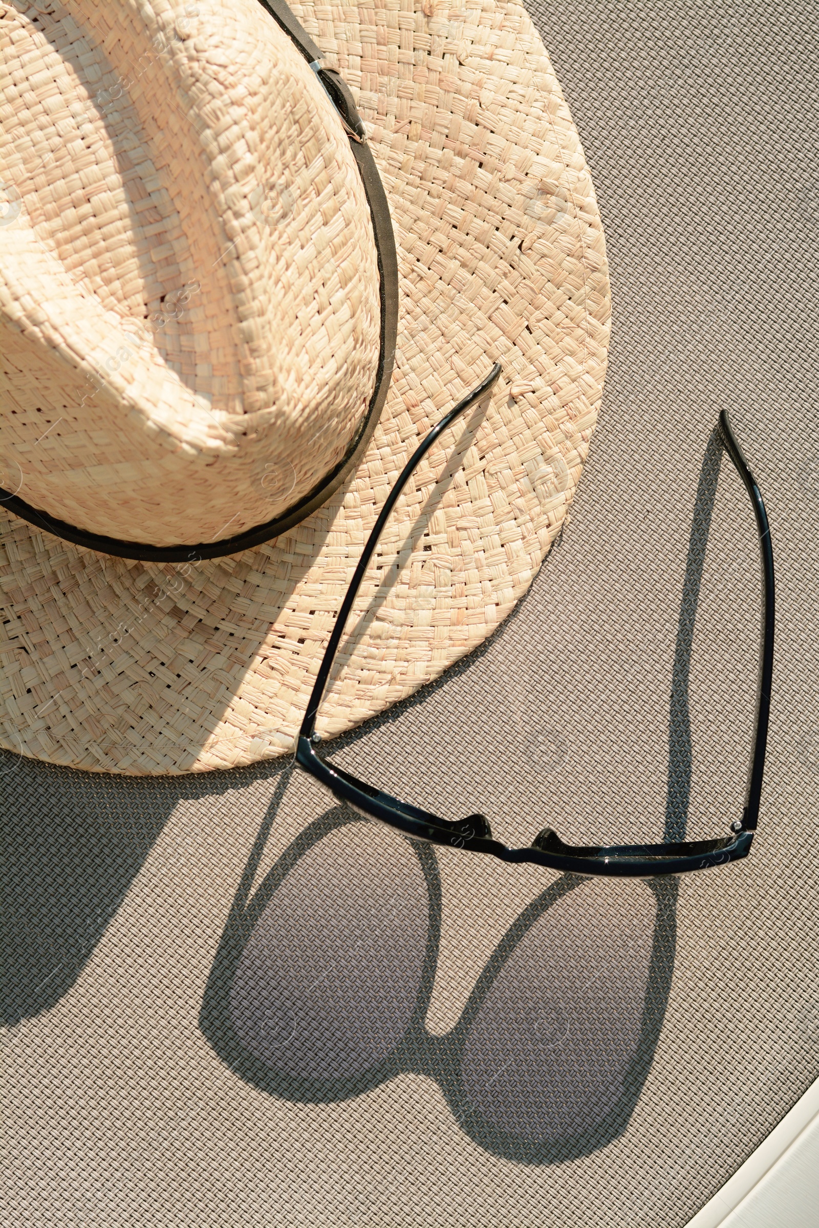 Photo of Stylish hat and sunglasses on grey surface, flat lay