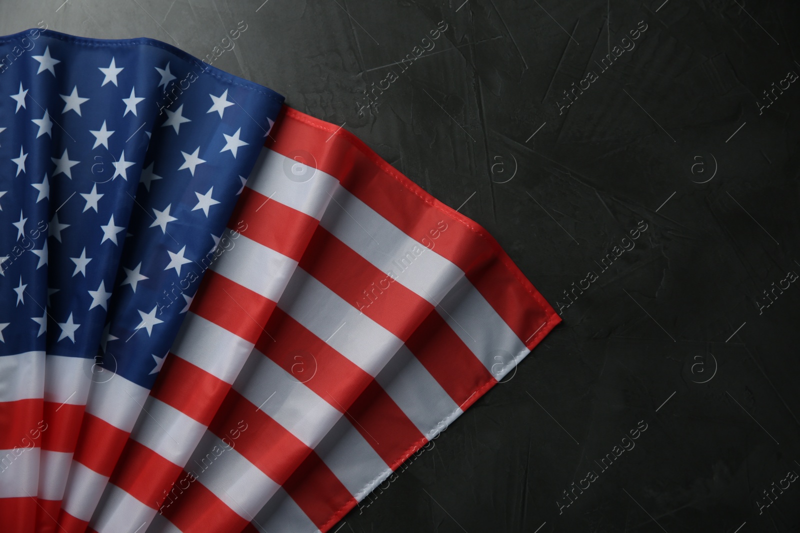 Photo of Flag of USA on black table, top view. Space for text