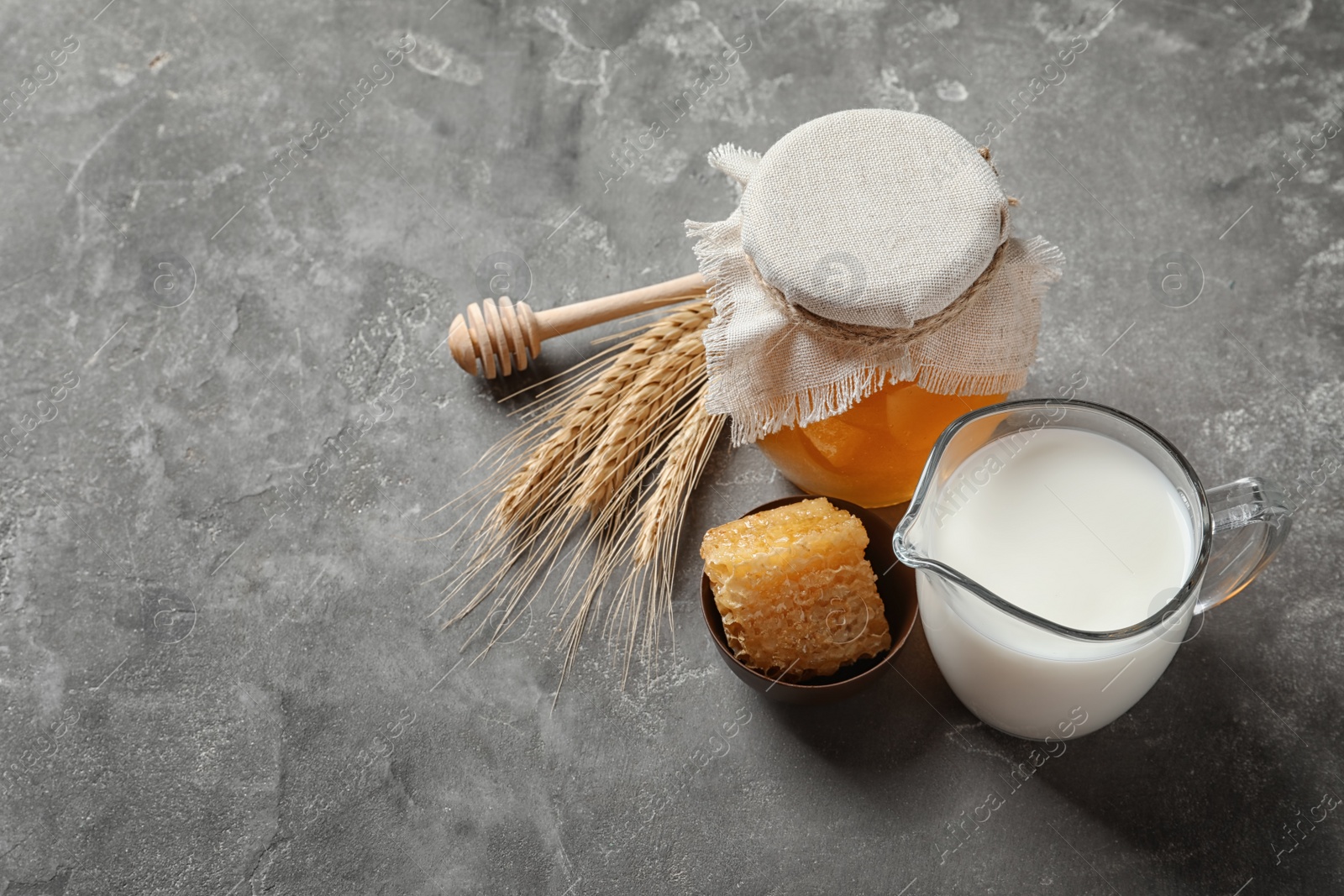 Photo of Beautiful composition with milk and honey on grey background