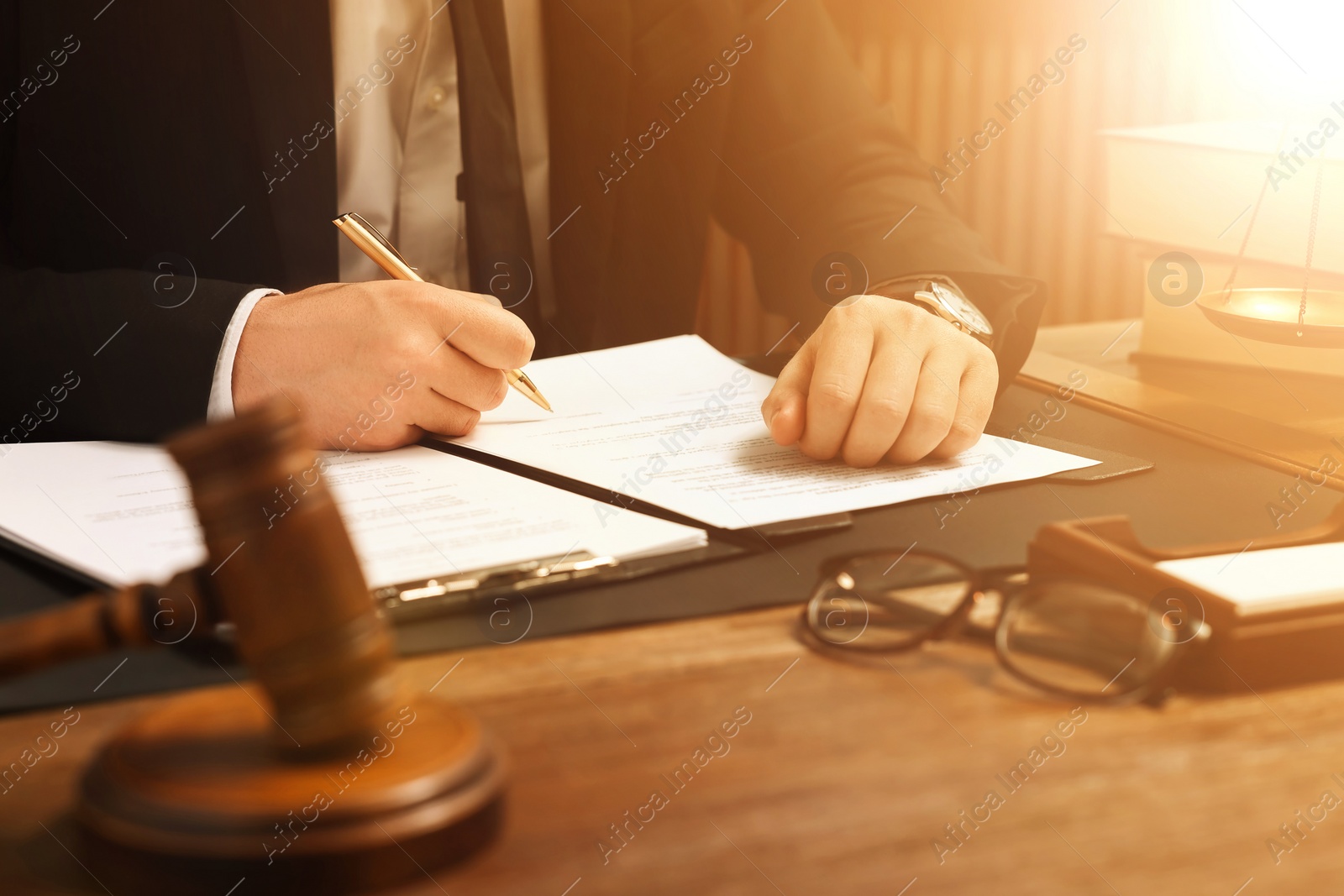 Image of Lawyer working with documents at wooden table in office, closeup