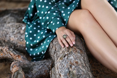 Young woman wearing beautiful silver ring with prehnite gemstone outdoors, closeup