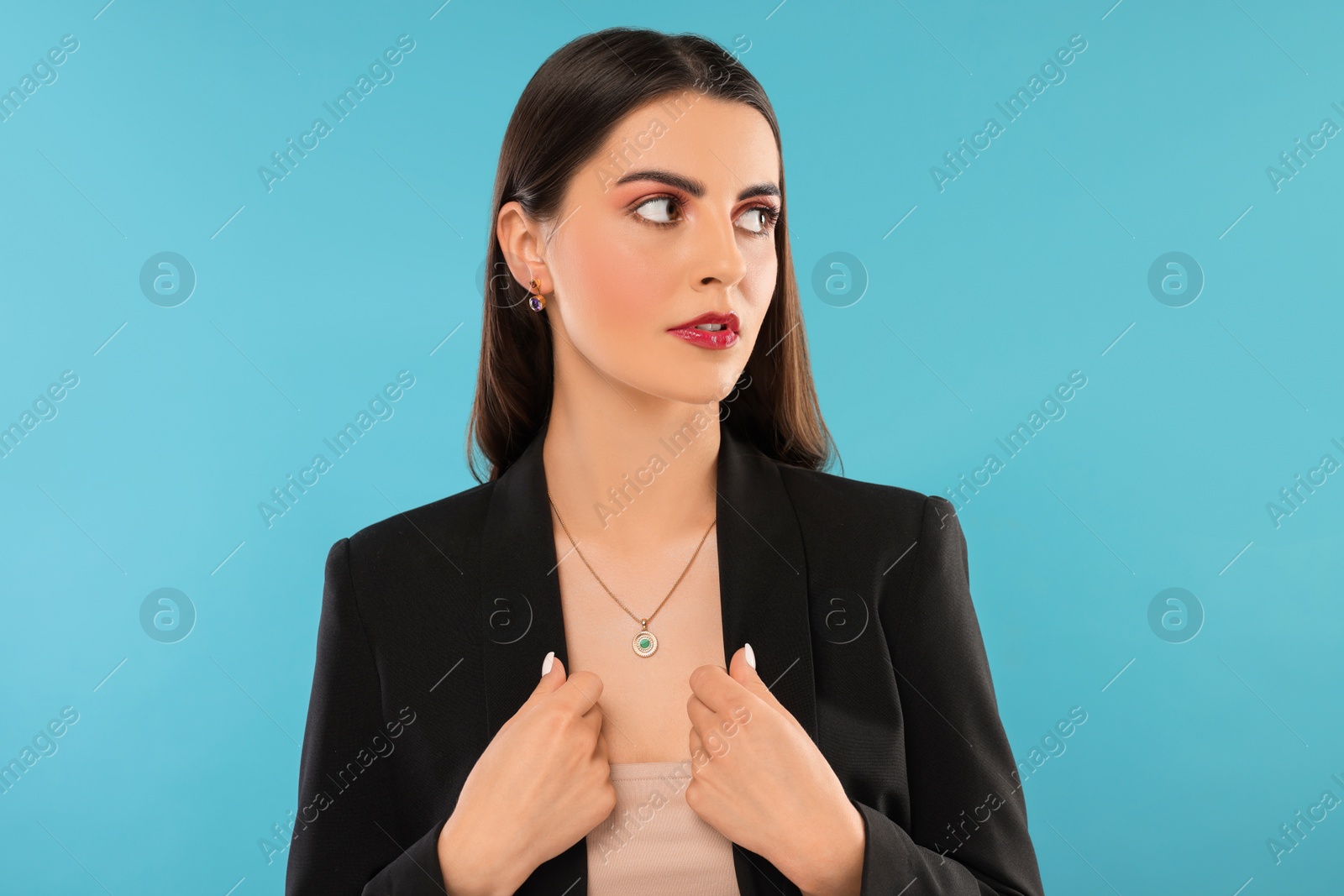 Photo of Beautiful woman with elegant jewelry on light blue background