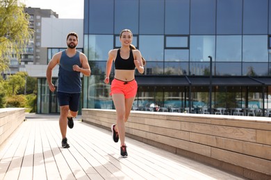 Photo of Healthy lifestyle. Happy couple running outdoors, space for text