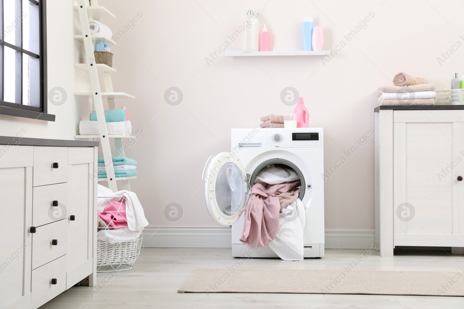 Photo of Bathroom interior with dirty towels in washing machine