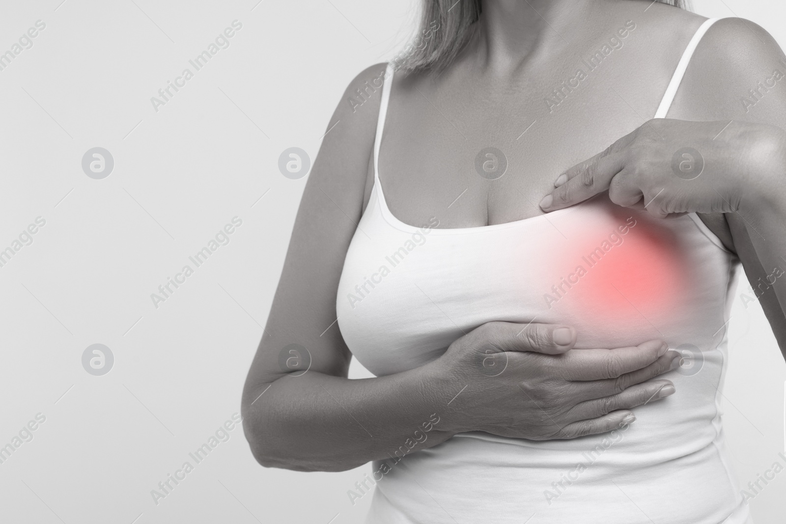 Image of Woman doing breast self-examination on light background, closeup. Color accent effect