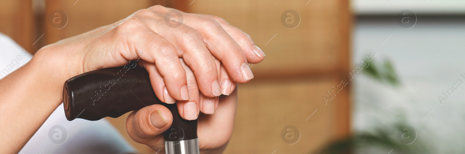 Image of Elderly woman with walking cane indoors, closeup. Banner design