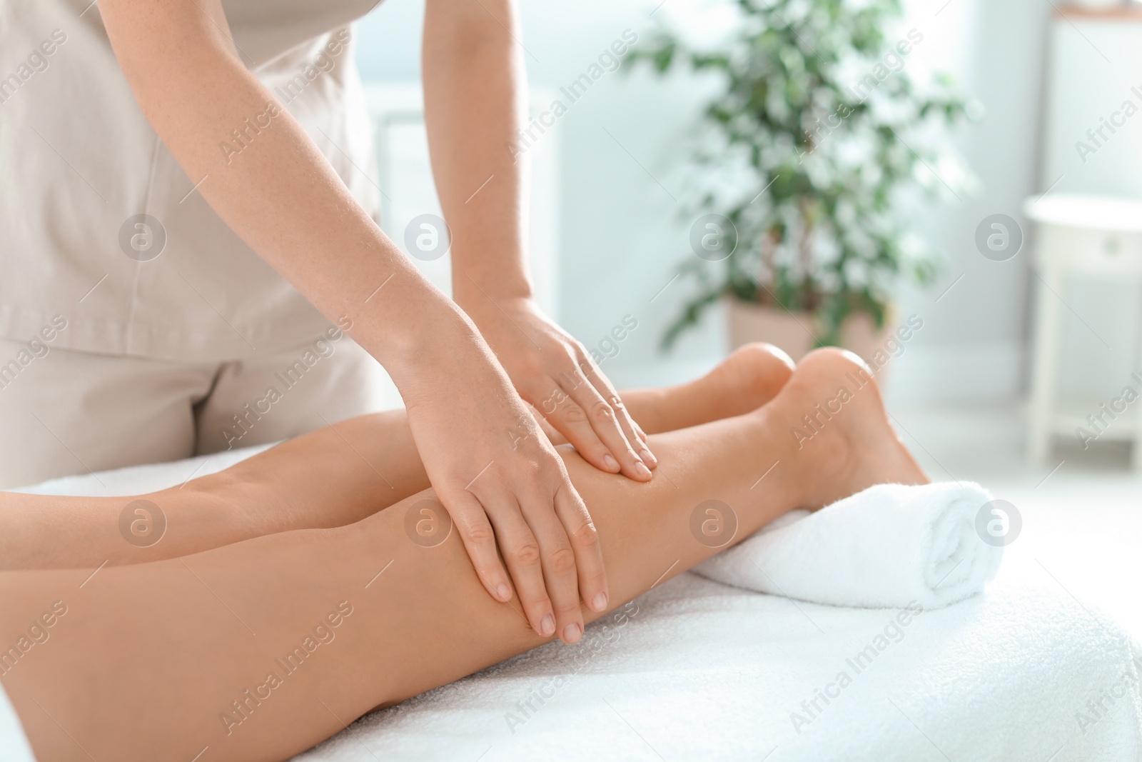 Photo of Woman receiving leg massage in wellness center, closeup