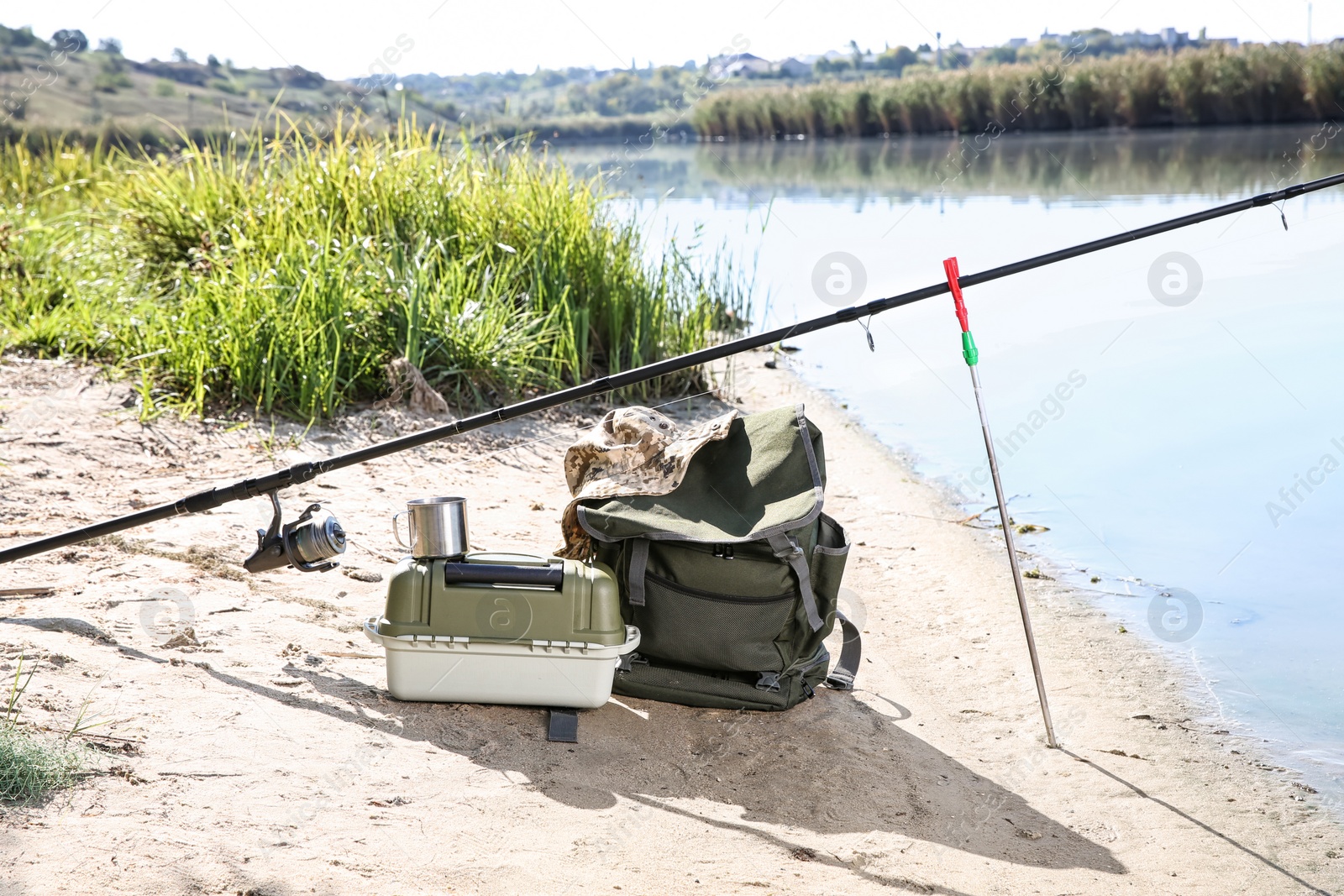 Photo of Rod and fishing essentials at riverside on sunny day