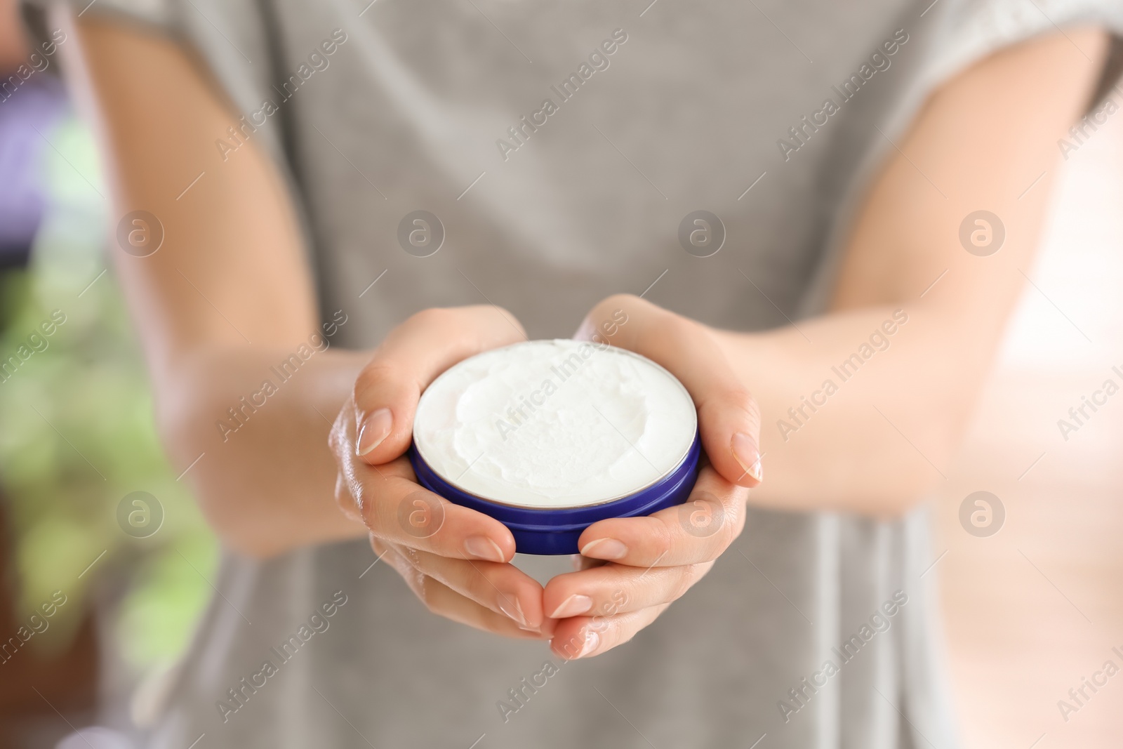 Photo of Young woman with jar of hand cream, closeup