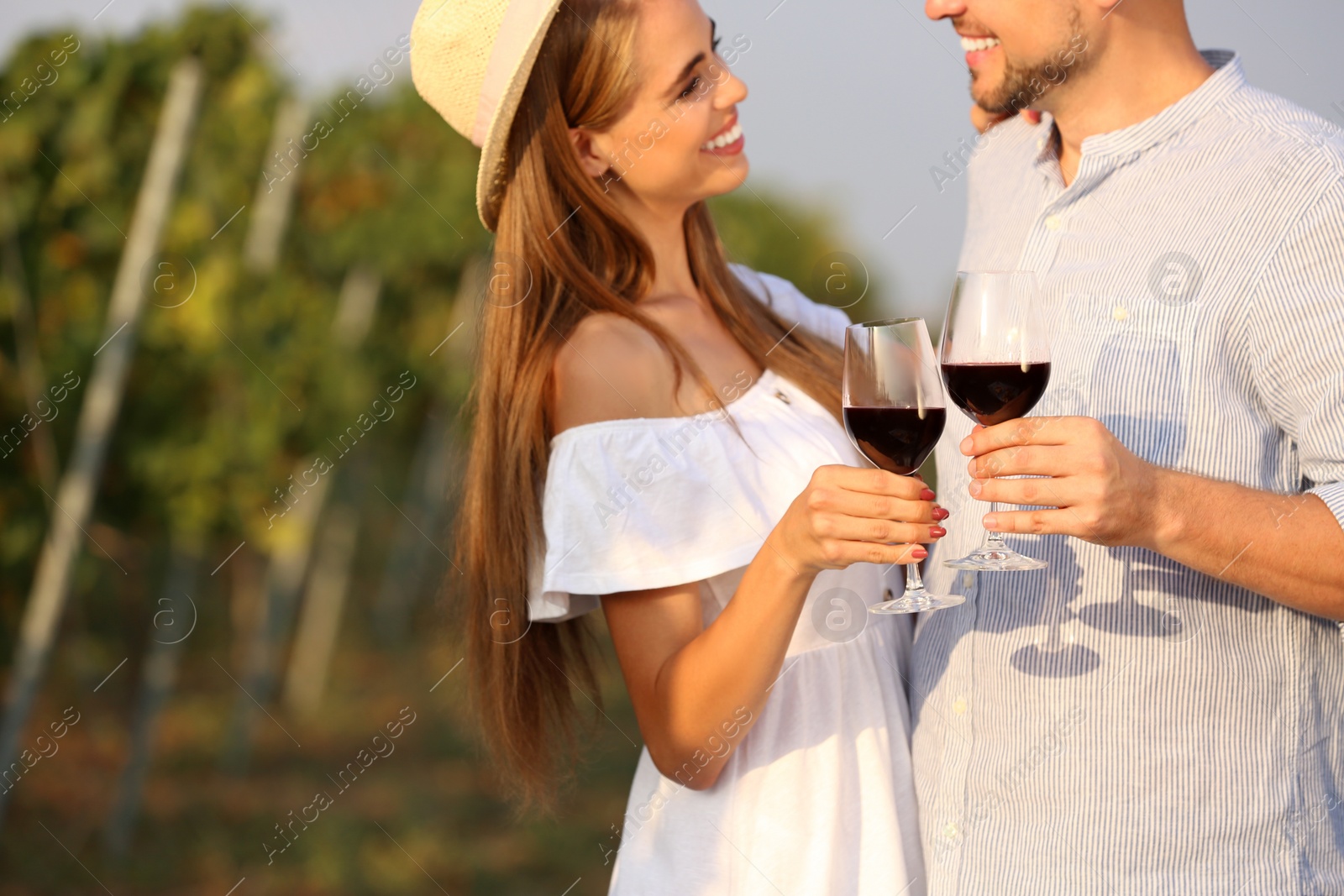 Photo of Happy couple holding glasses of wine outdoors, closeup view