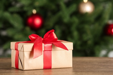 Photo of Christmas gift on table against blurred background