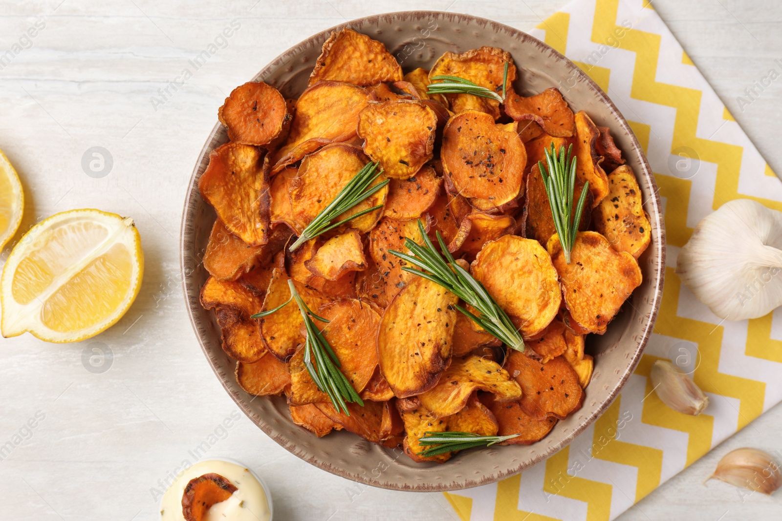 Photo of Flat lay composition with plate of sweet potato chips on light table