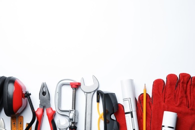 Composition with different construction tools on white background, top view