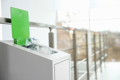 Photo of Metal bin with garbage indoors, space for text. Waste recycling