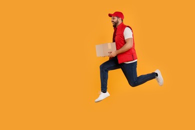 Photo of Smiling courier running to deliver parcel on orange background, space for text