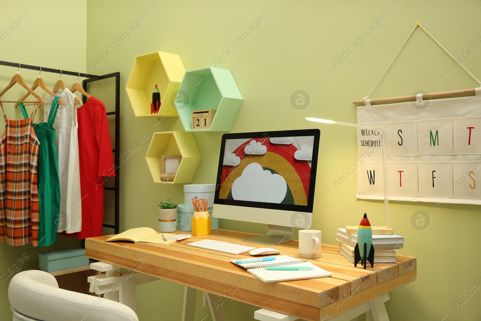 Photo of Stylish workplace with computer on wooden desk indoors. Interior design