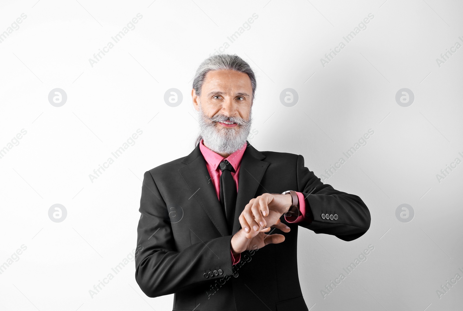 Photo of Handsome bearded mature man in suit on white background