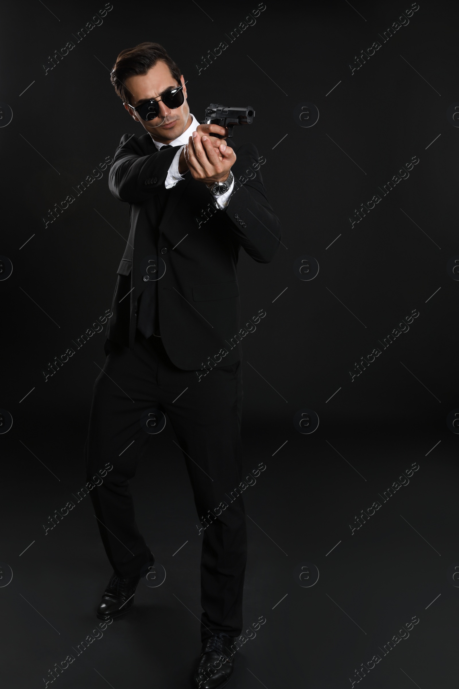 Photo of Male security guard in uniform with gun on dark background