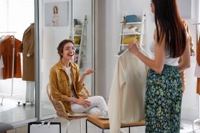 Photo of Young women choosing clothes in modern boutique