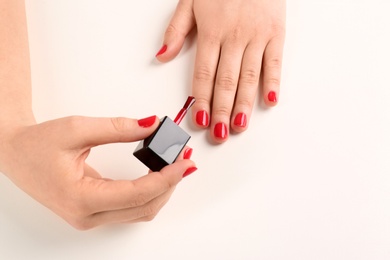 Woman applying nail polish on white background, closeup