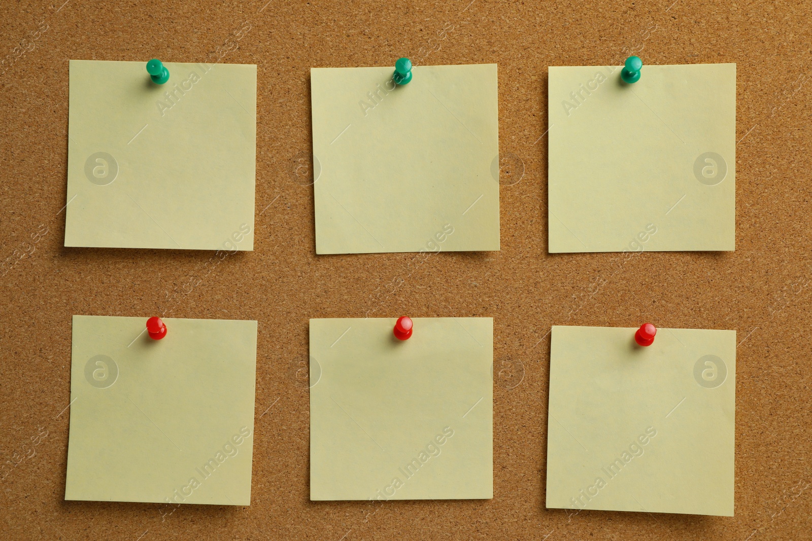 Photo of Beige paper notes pinned to cork board