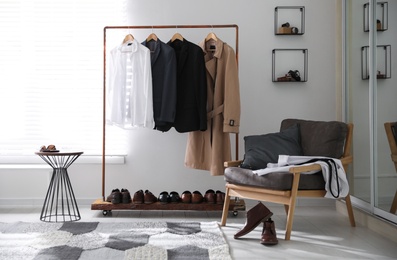 Photo of Dressing room interior with clothing rack and armchair