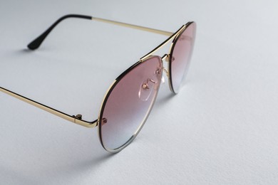 Photo of New stylish sunglasses on white background, closeup