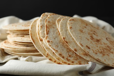 Tasty homemade tortillas and cloth on table