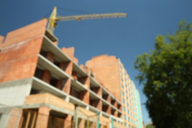 Photo of Blurred view of unfinished building and tower crane outdoors