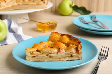 Slice of traditional apple pie on wooden table