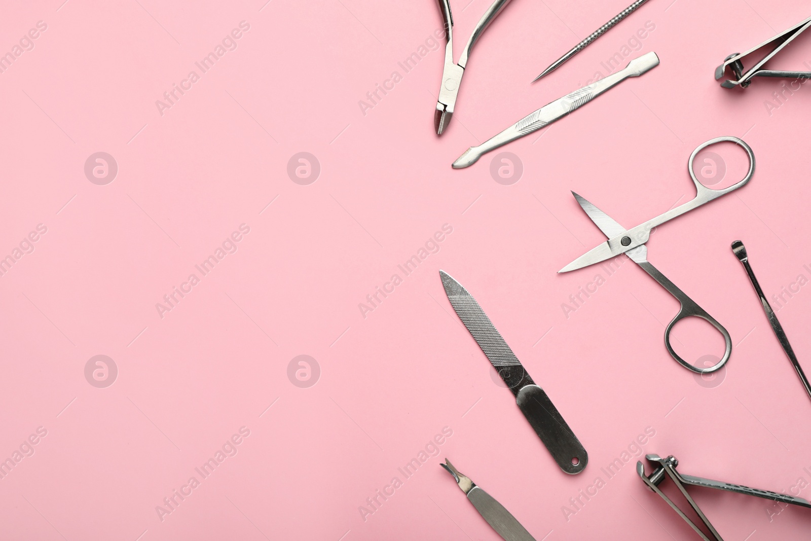 Photo of Setmanicure tools on pink background, flat lay. Space for text