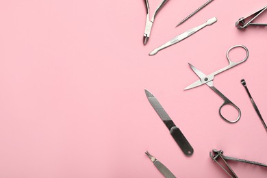 Photo of Set of manicure tools on pink background, flat lay. Space for text
