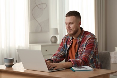 Photo of Online test. Man studying with laptop at home