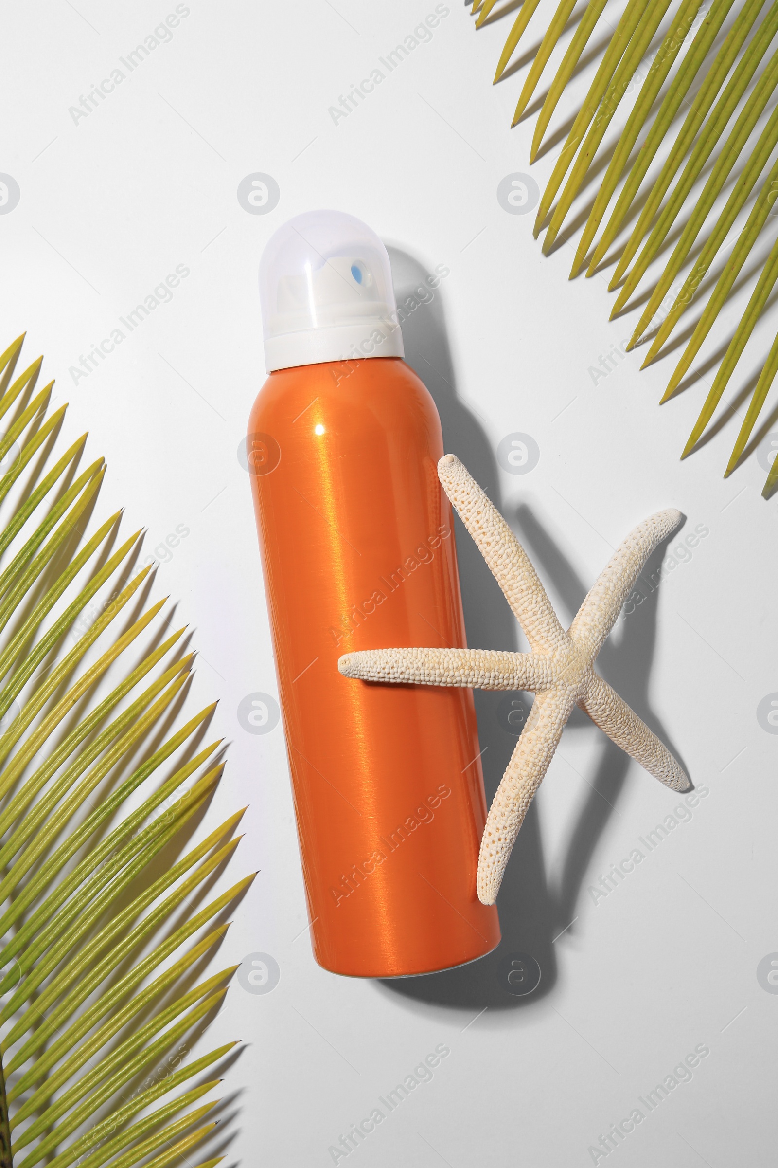 Photo of Sunscreen, starfish and tropical leaves on white background, flat lay. Sun protection care