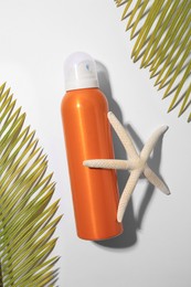 Sunscreen, starfish and tropical leaves on white background, flat lay. Sun protection care