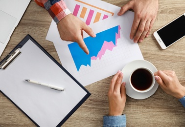 Photo of Business trainer and client working at table in office, top view