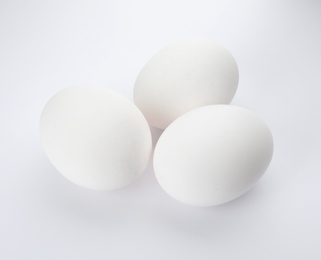 Photo of Few raw chicken eggs on white background