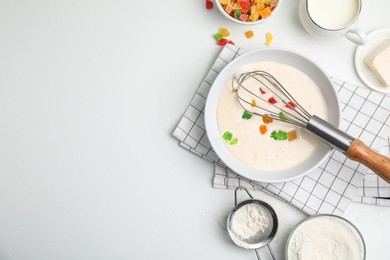 Photo of Flat lay composition with raw dough, candied fruits and other ingredients on white table, space for text