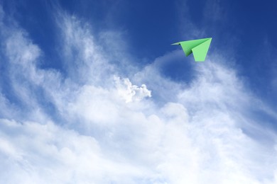 Image of White clouds and paper airplane flying in blue sky on sunny day. Space for text