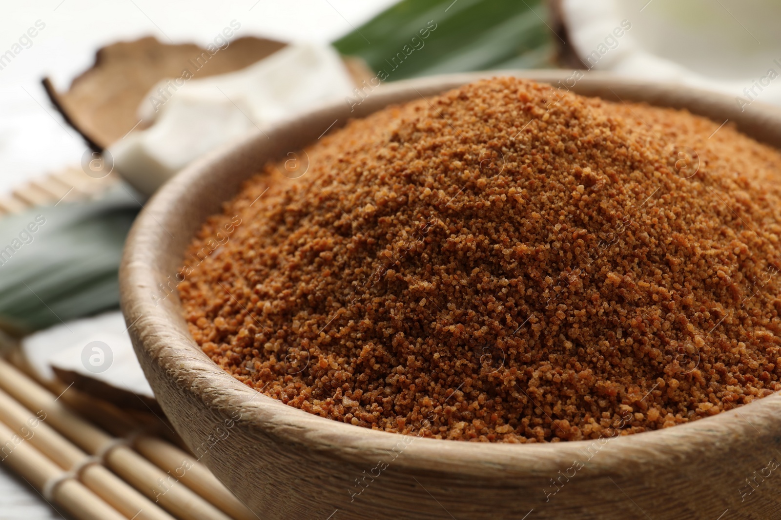 Photo of Natural coconut sugar in wooden bowl, closeup