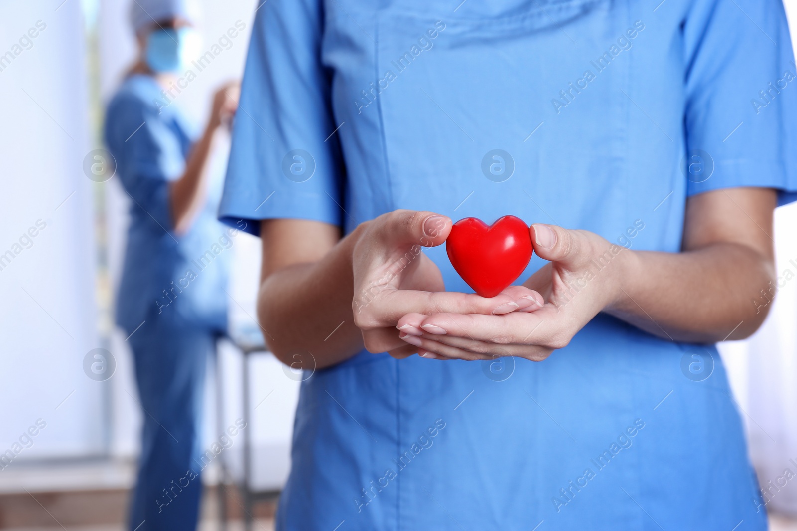 Photo of Doctor holding red heart at hospital, closeup. Donation day