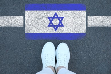 Image of Immigration. Woman standing on asphalt near flag of Israel, top view