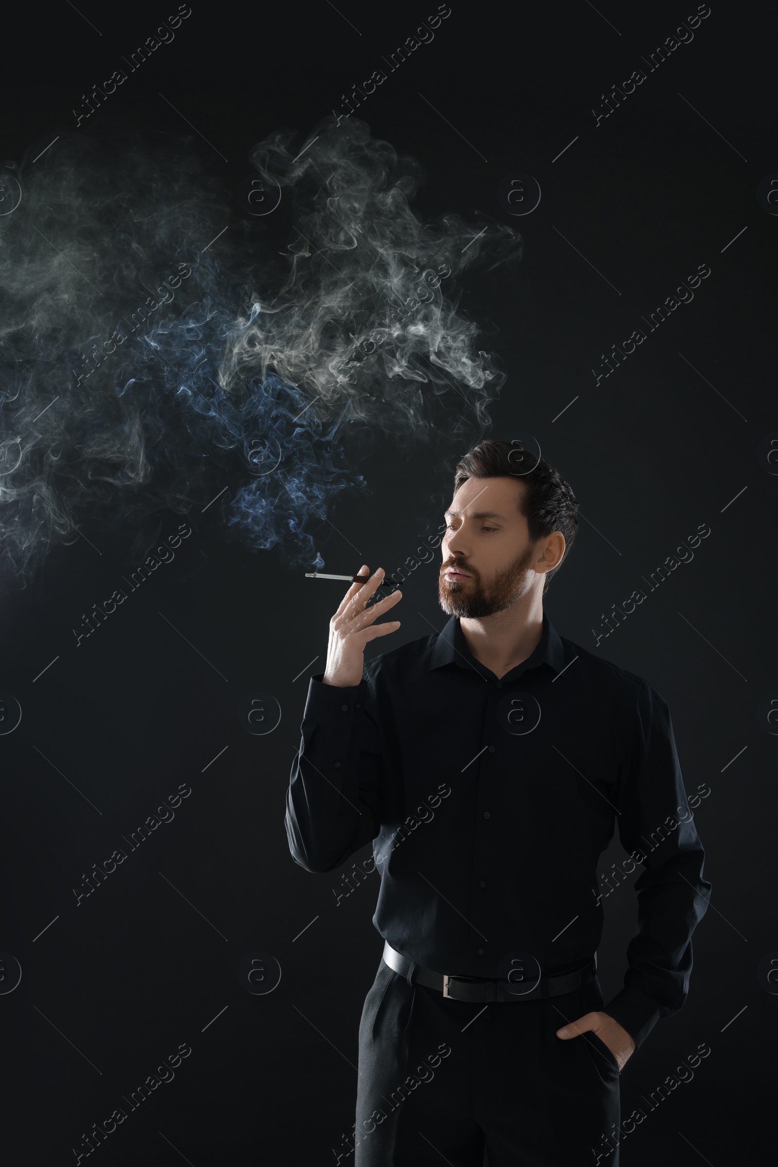 Photo of Man using cigarette holder for smoking on black background, space for text