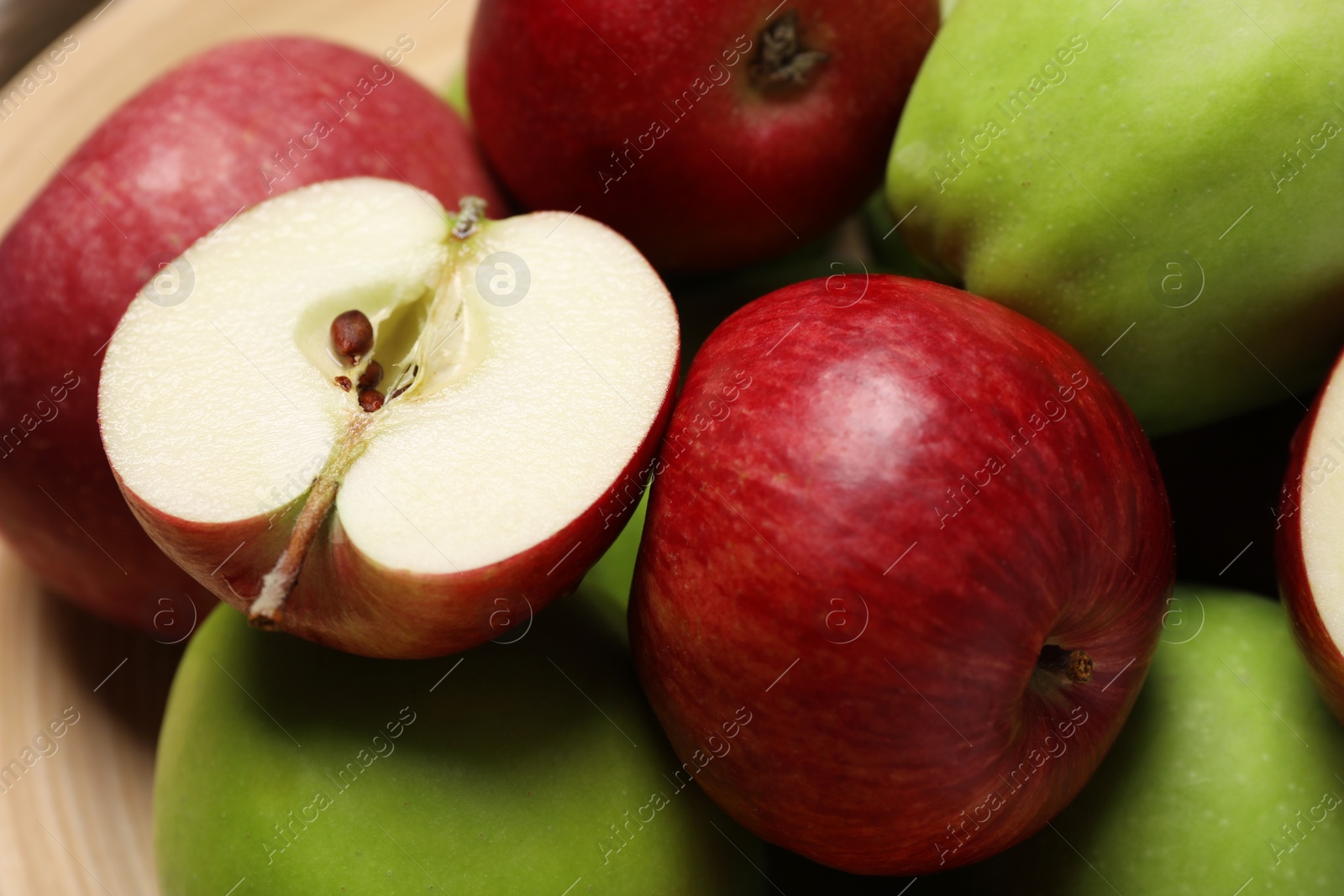 Photo of Fresh ripe apples on wooden plate, closeup