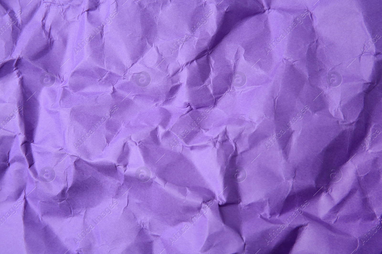 Photo of Sheet of crumpled violet paper as background, top view