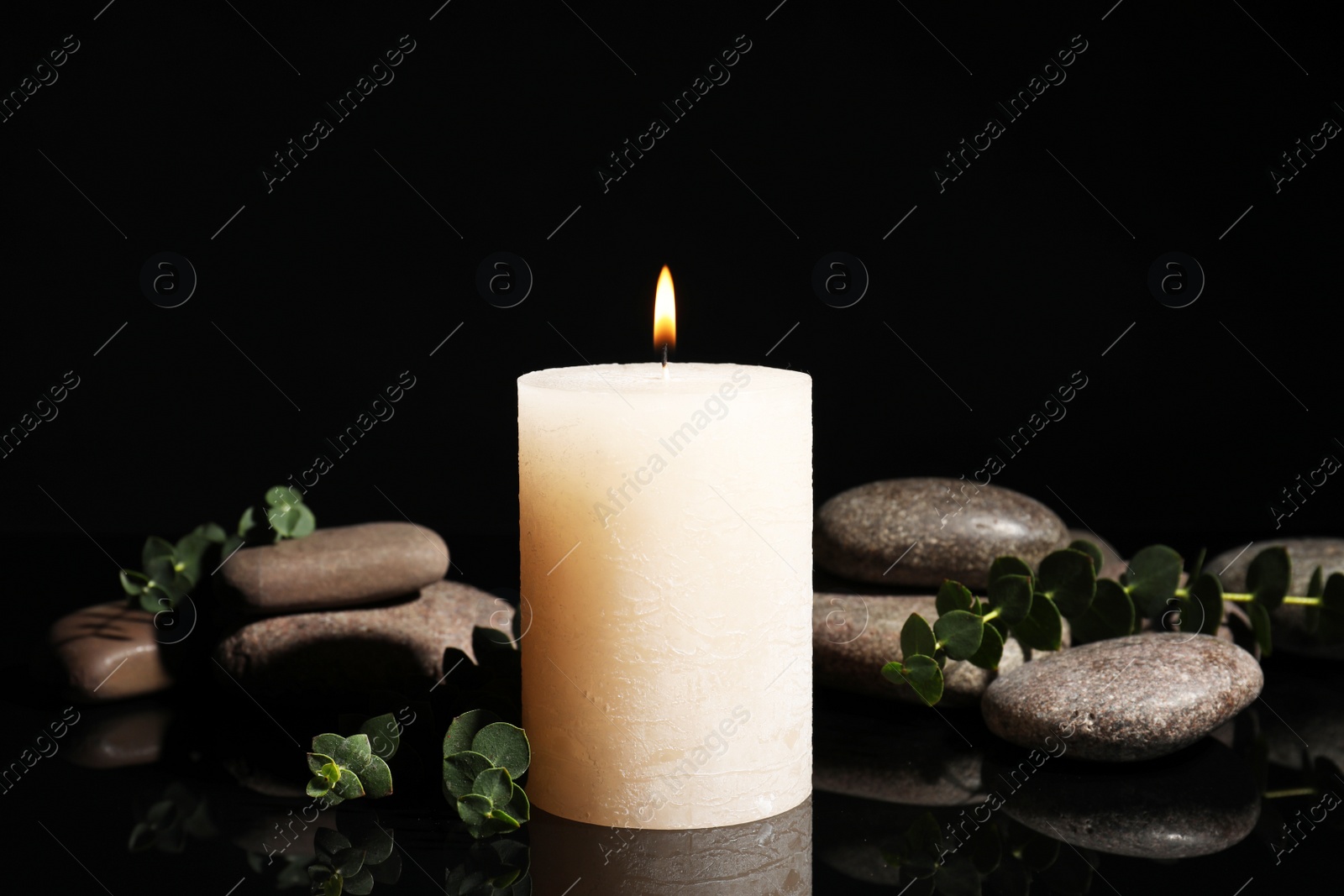 Photo of Composition with candle and spa stones on black background