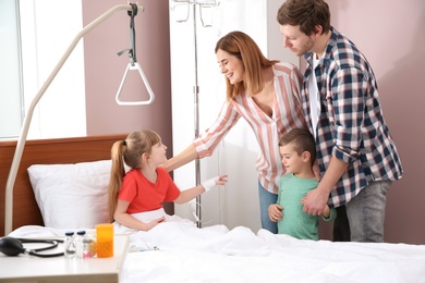 Happy family visiting little child in hospital