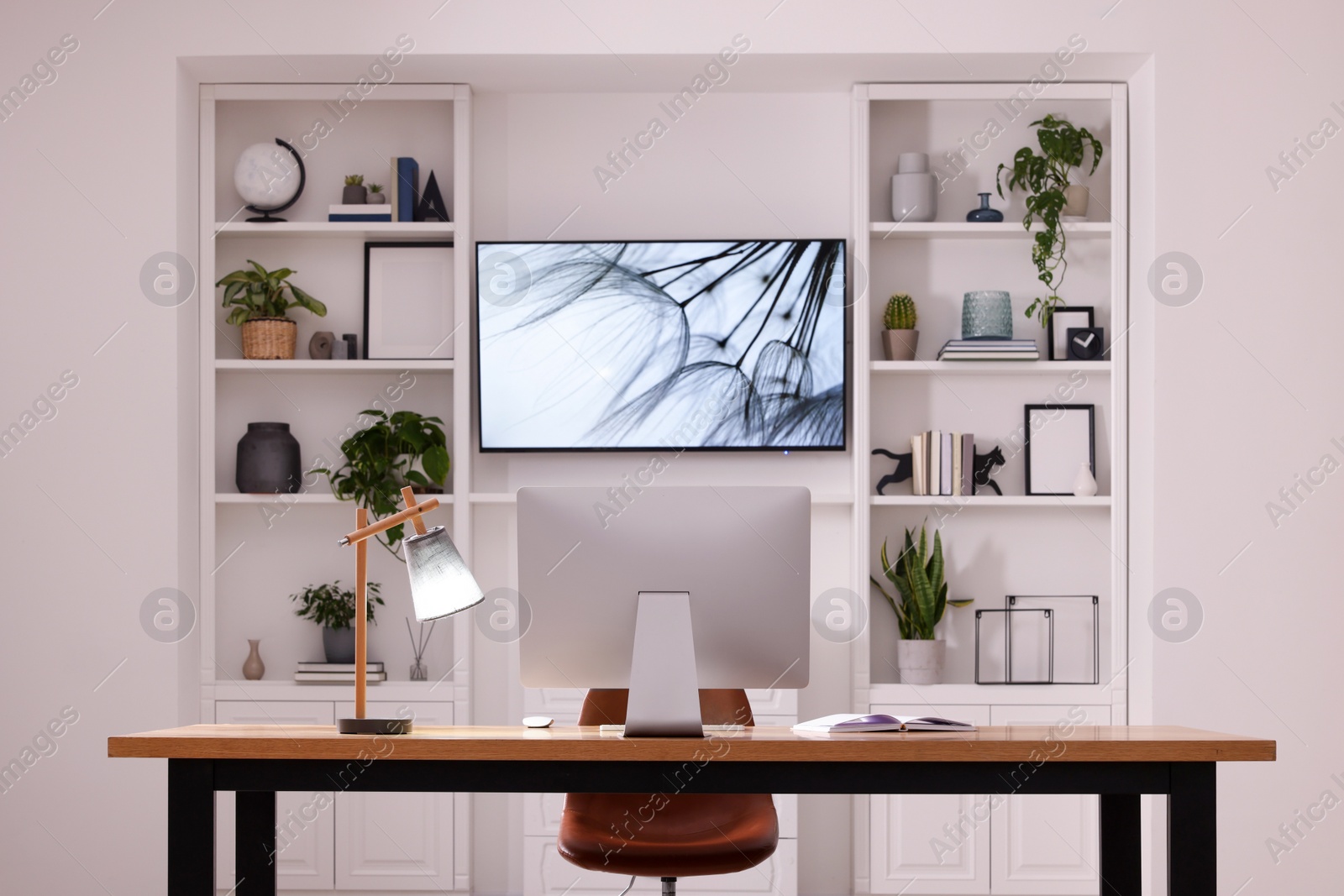 Photo of Cosy workplace with computer near tv area. Interior design