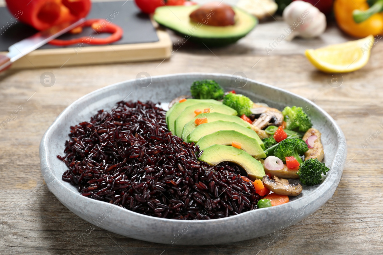 Photo of Plate of cooked brown rice with avocado on table